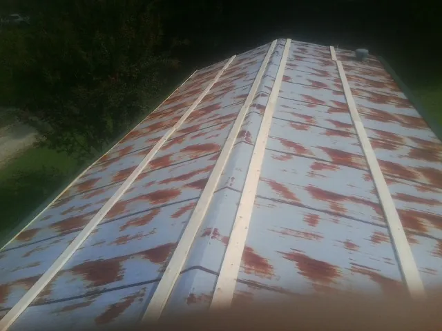 Rusted metal roof panels with new wood purlins before replacement — Storm Damage Roof Repair in Mc Kee by Roofing Brothers