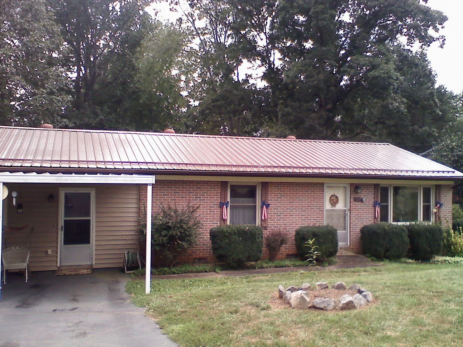 Bronze metal roof and carport on a brick ranch home — Roof Repair work by our crew in Mc Kee